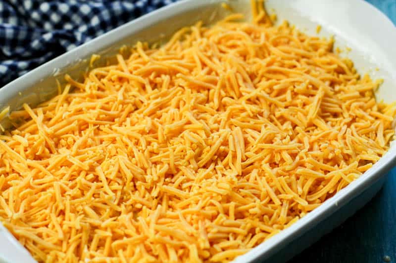 Shredded cheddar cheese in a white pan