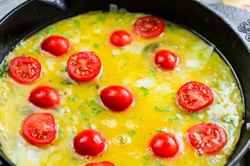 egg mixture and tomatoes in pan