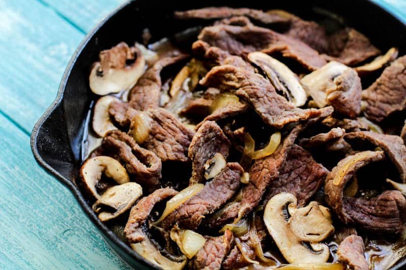 cooked steak and mushrooms in pan