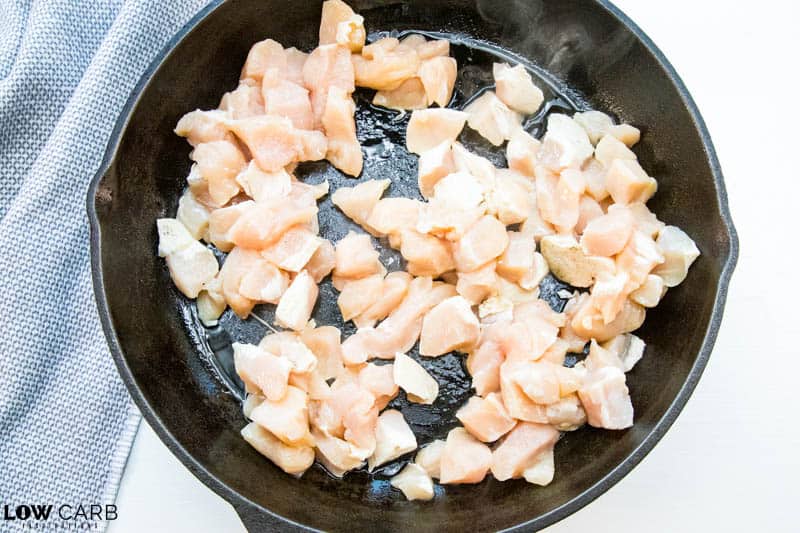 raw chicken in a cast iron pan