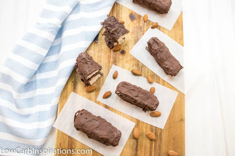 Almond joy fat bombs laying on a cutting board with a blue and white cloth in the background