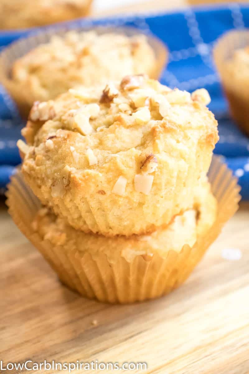 Banana Nut Keto Breakfast Muffins laying on a wooden cutting board with blue cloth in the background