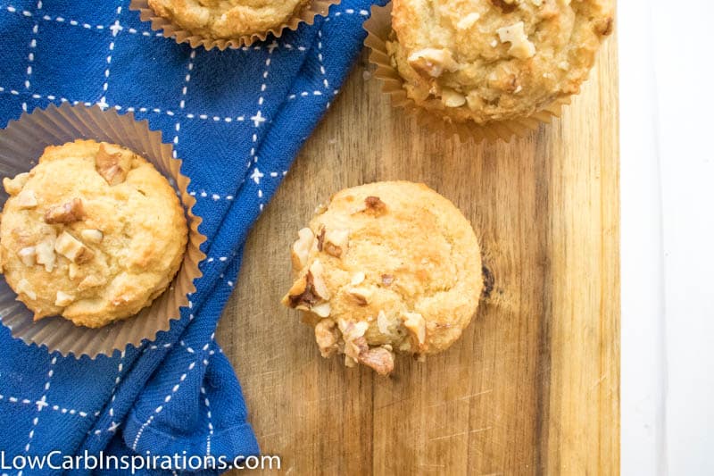 Overhead picture of keto banana nut muffins laying on a cutting board with blue cloth in the background