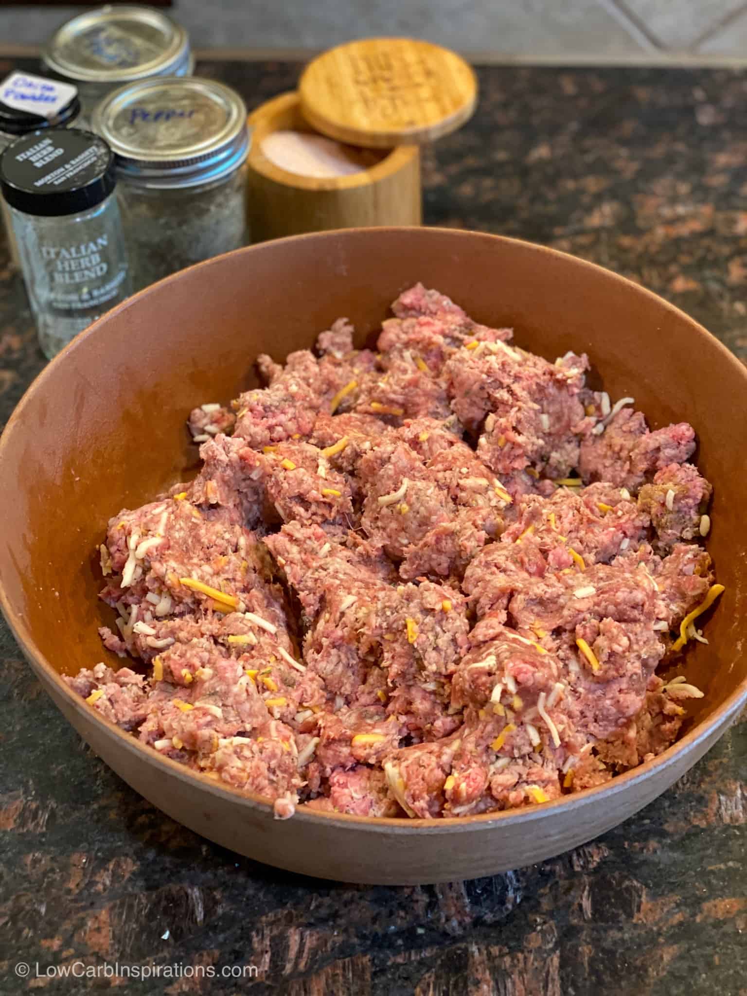 Ground beef and ground pork in a bowl with all the other meatza ingredients