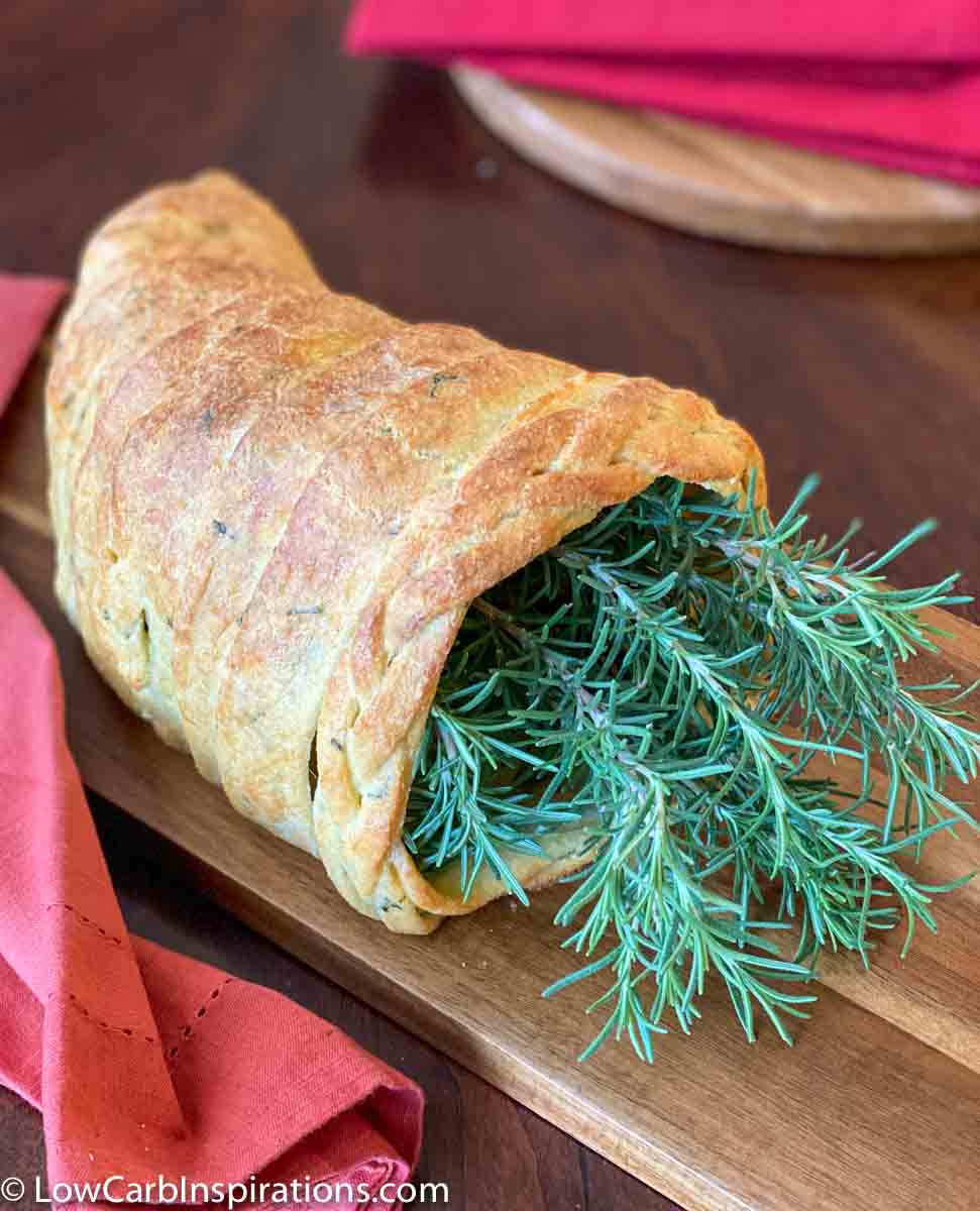 Keto Cornucopia Bread Recipe stuffed with rosemary and set on a cutting board to display