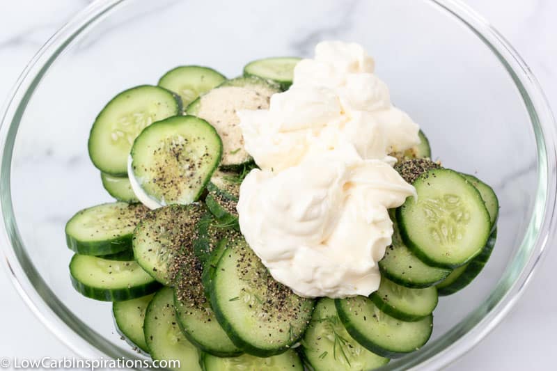 cucumber salad ingredients unmixed in a clear bowl