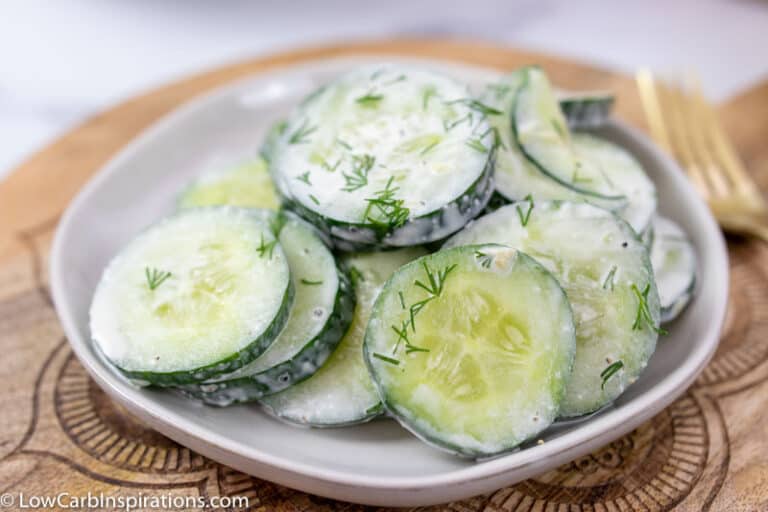close up of dill cucumber salad on a white plate