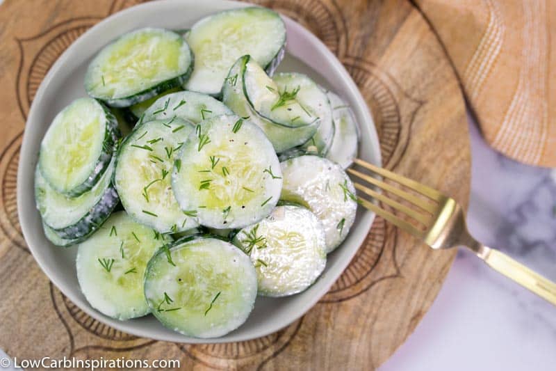 Dill Cucumber Salad Recipe on a white plate with a fork on the side