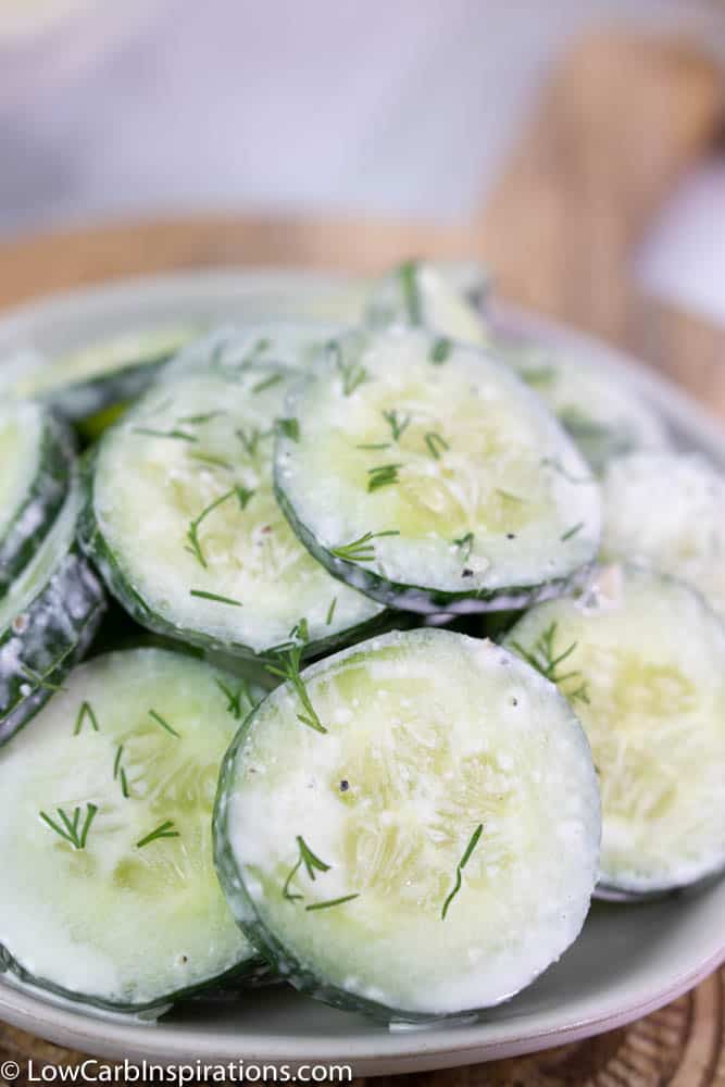 close up of dill cucumber salad on a white plate