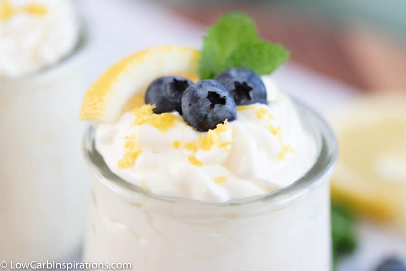 lemon blueberry mousse recipe in a small clear glass topped with blueberries, lemon slice and mint