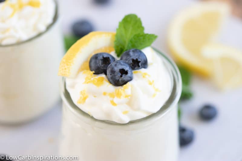 lemon blueberry mousse recipe in a small clear glass topped with blueberries, lemon slice and mint