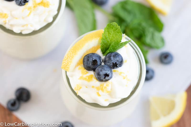Low Carb Lemon Mousse with lemon and blueberries in a small clear glass