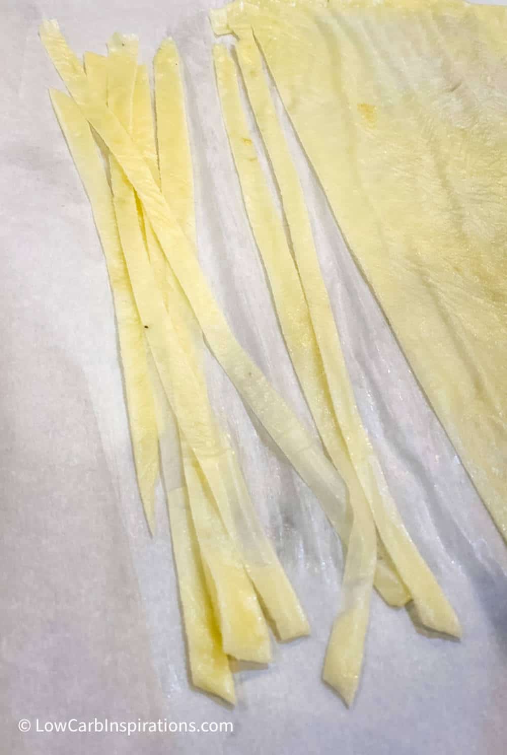 Long strands of keto pasta noodles on parchment paper