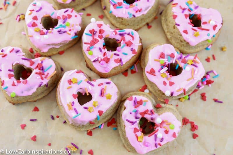 heart shaped glazed donuts with sprinkles on a table