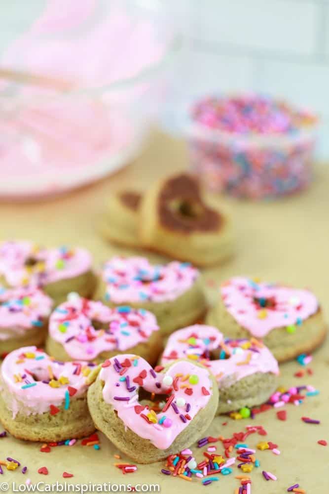 heart shaped keto glazed donuts with sprinkles on a table