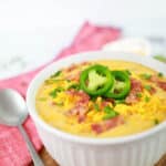close up of Keto Bacon Cheddar Soup Recipe in a white bowl on a table ready to eat