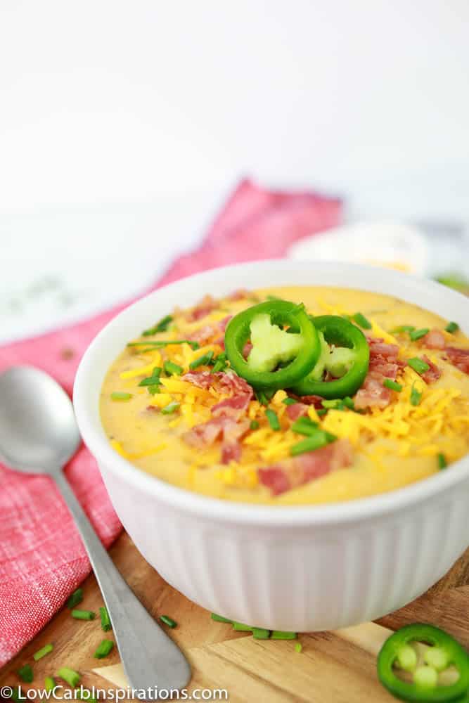 close up of Keto Bacon Cheddar Soup Recipe in a white bowl on a table ready to eat