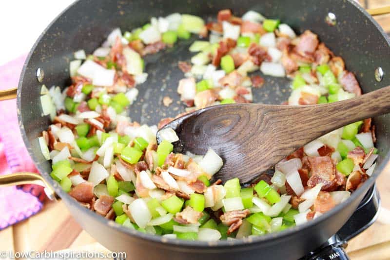 fully cooked bacon, celery and onions in a black skillet
