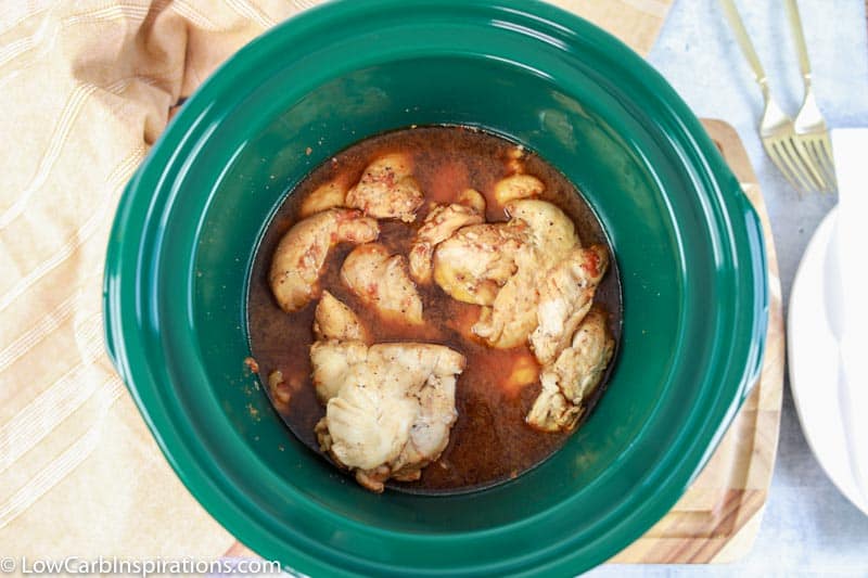overhead photo of fully cooked bourbon chicken in a crockpot
