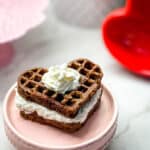 Heart shaped chocolate waffle cake on a pink cake plate stand