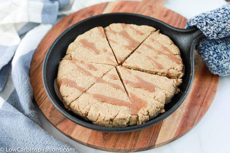 Baked cinnamon scones in a cast iron skillet with cinnamon drizzled on top