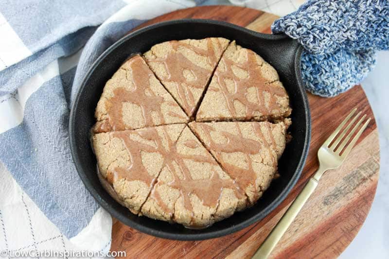 delicious cinnamon scones in a cast iron skillet with cinnamon drizzled on top