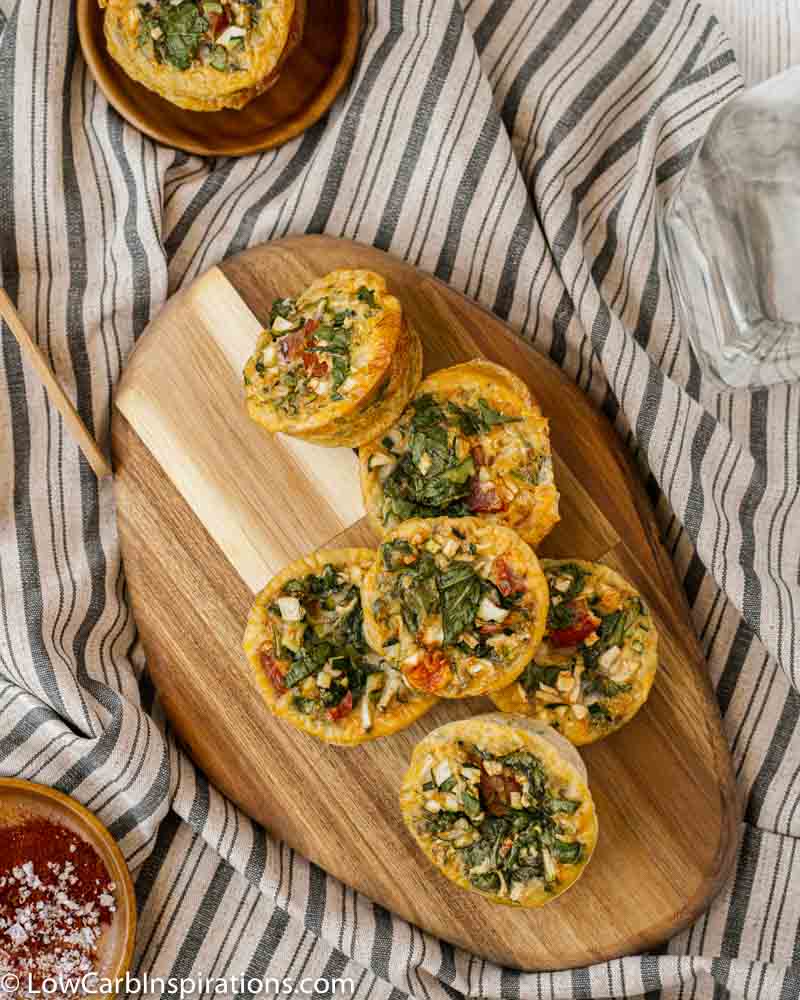 overhead photo of stacked zucchini egg muffins on a wood cutting board