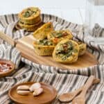 stacked zucchini egg muffins on a wood cutting board