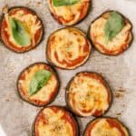 overhead close up photo of Mini Eggplant Margherita Pizza Recipe on a baking sheet with parchment paper