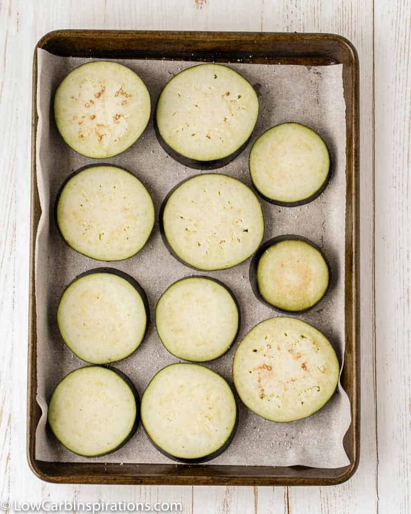 eggplant slices on a baking sheet with parchment paper on a counter