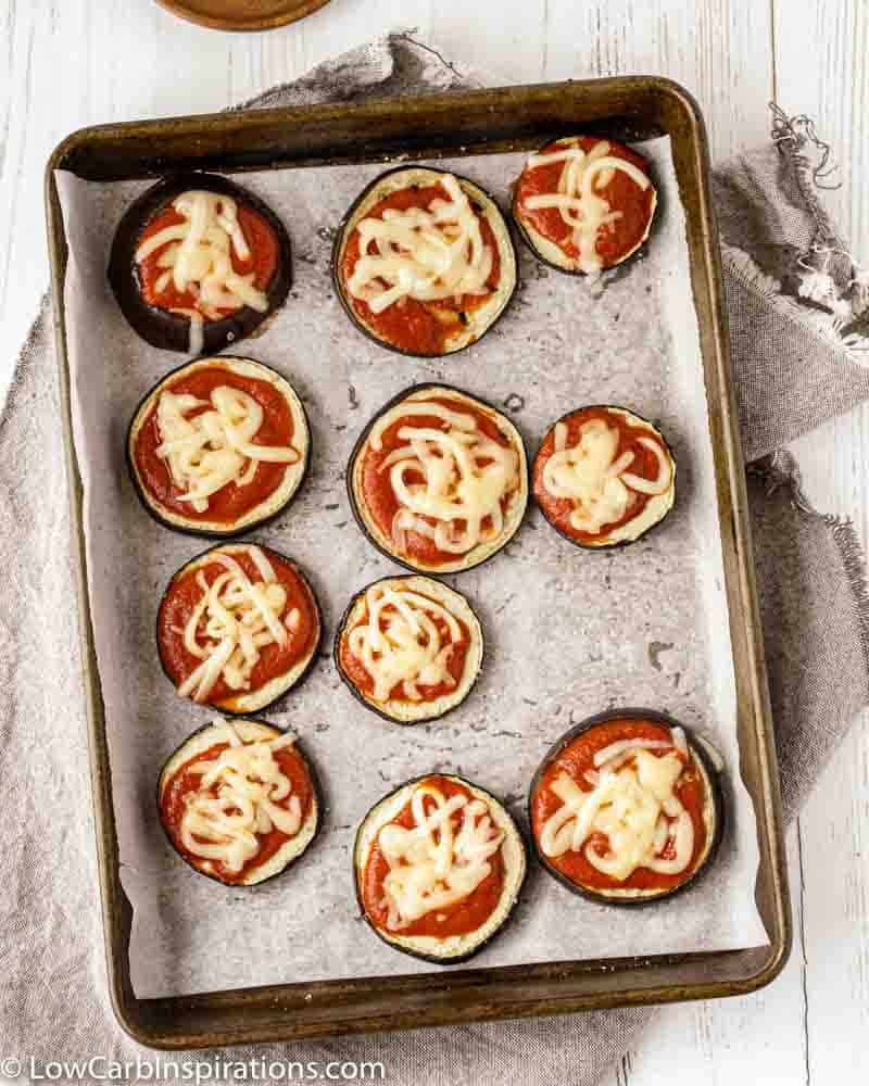 eggplant pizza bites on a baking sheet with parchment paper ready to go in the oven