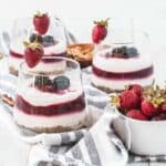 yogurt parfait recipe on a table with strawberries next to it and more parfaits in the background