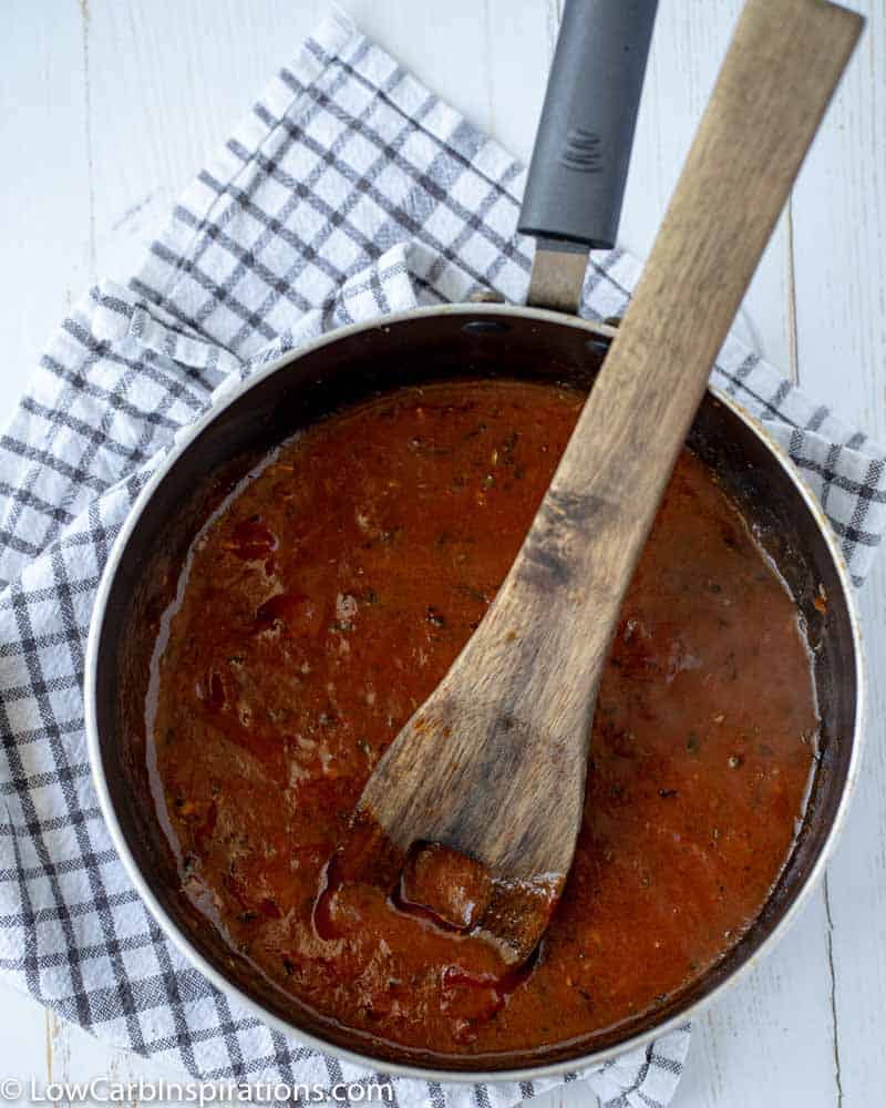 pizza sauce in a saucepan with a wooden spoon