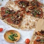 Mushroom Pizza Recipe with Cauliflower Crust cut into slices on parchment paper