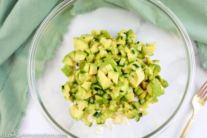 mashed avocado and eggs in a clear mixing bowl