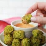 keto broccoli bites on a white plate with a white bowl of sriracha dipping sauce