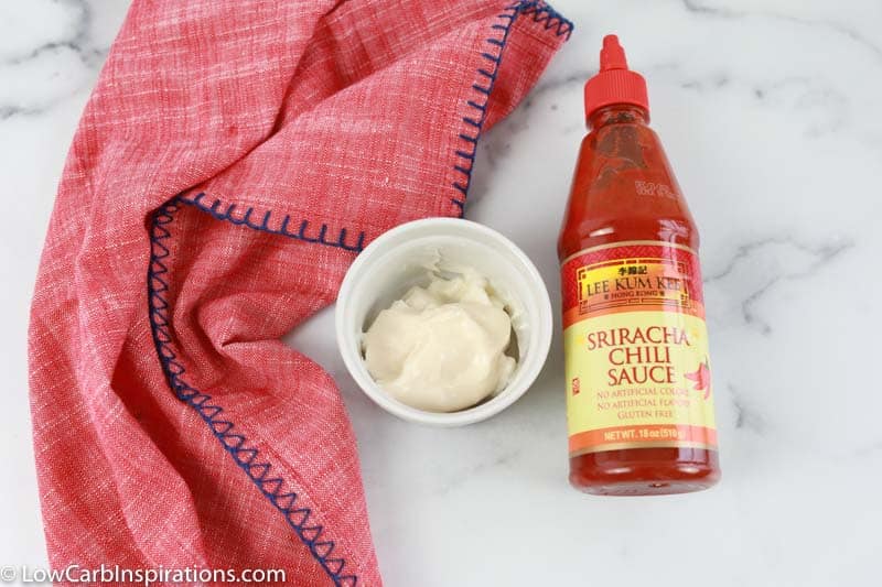 sriracha sauce ingredients in a white bowl with sriracha and a pink towel on the side 