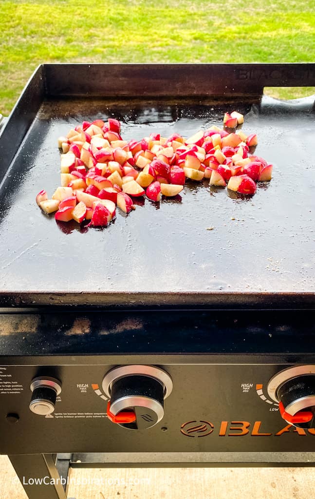 Grill with radishes cooking on the griddle part.