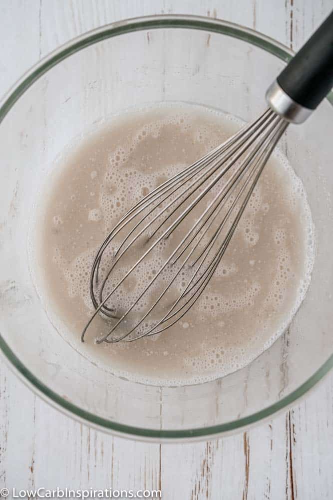 sugar free glaze ingredients in a clear bowl mixed together with a whisk