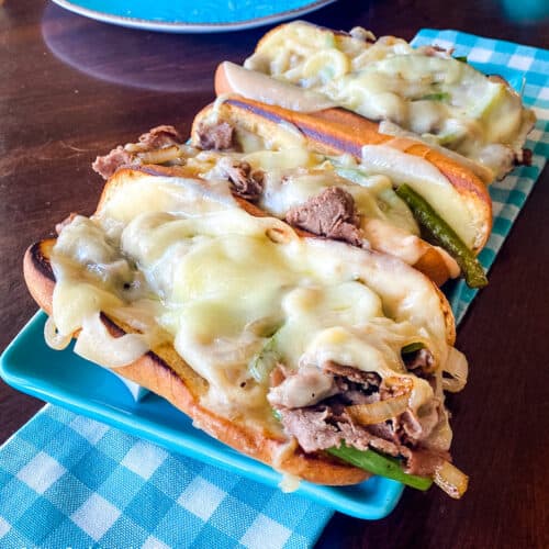 Philly Cheesesteak sandwich on a blue plate with a blue napkin