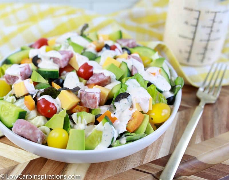 close up of keto salad dressing recipe on a salad with ranch dressing in the background