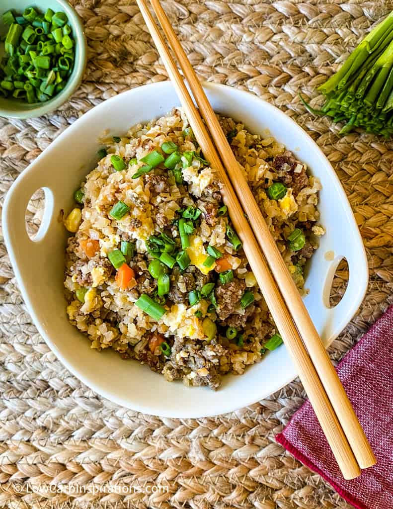 Bowl of fried rice with chopsticks and a side bowl of chive onions