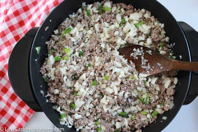 ground beef cooking in a skillet with cauliflower and vegetables