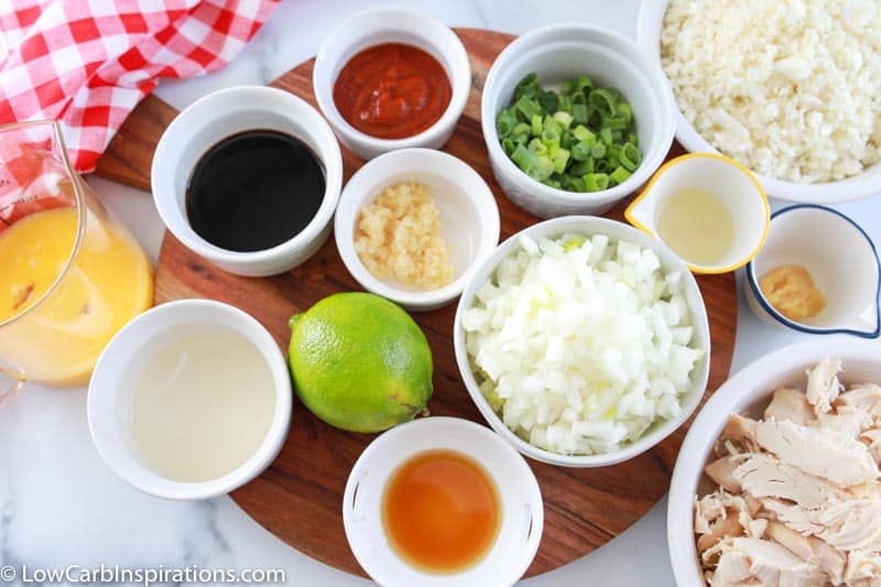 Keto Spicy Chicken Cauliflower Fried Rice Recipe ingredients in white bowls on a wooden board