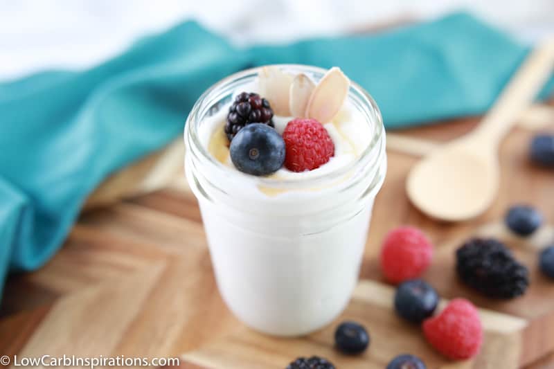 close up photo of easy yogurt recipe ready to eat with a wood spoon and mixed berries on the side