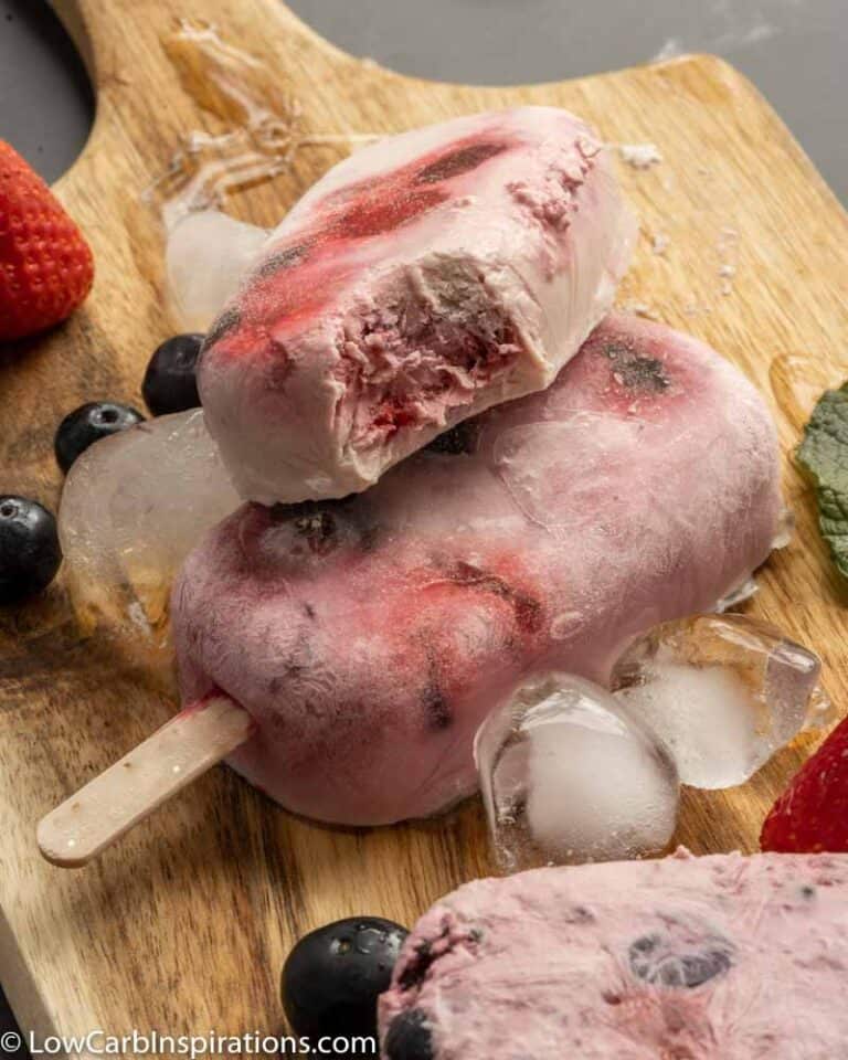 close up of Keto Triple Berry Popsicles on a wooden board