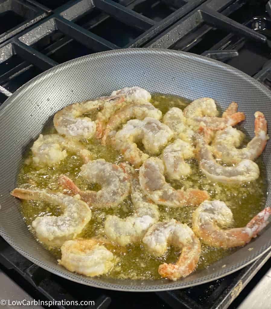 shrimp cooking in oil on a gas stove