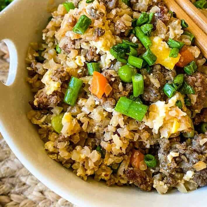 Close up of a bowl of fried rice with mixed veggies