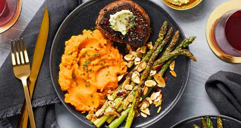 Peppercorn-Crusted Beef Tenderloin with Chive Butter, Asparagus Amandine, and Mashed Sweet Potatoes