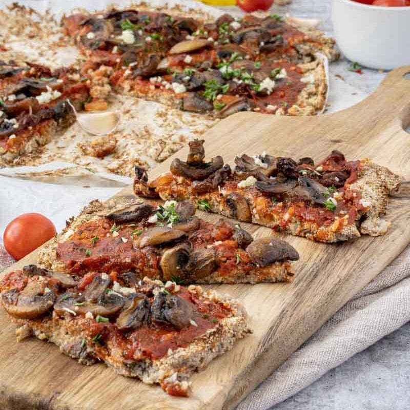 close up of Mushroom Pizza Recipe with Cauliflower Crust on a wood serving board